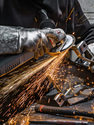 View of worker grinding a piece of metal
